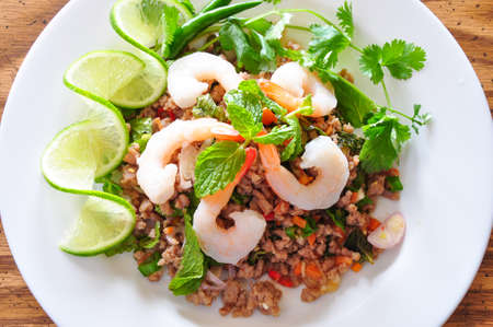 Thai spicy pork and shtimp salad served with fresh lime and cilantroの写真素材