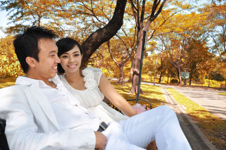 Married couple romantically sitting in a parkの写真素材