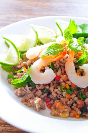Thai spicy pork and shtimp salad served with fresh lime and cilantroの写真素材