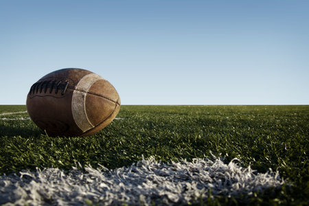 American football laying on a field.