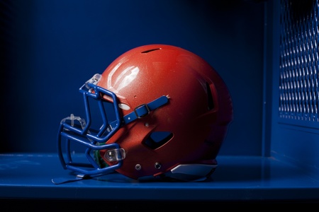 An american football helmet sits in an empty locker. Dramatic lighting. の写真素材