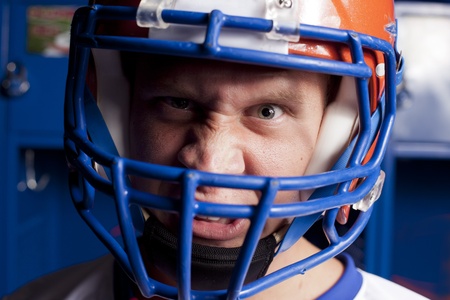 Close up of an american football player with helmet in locker room. の写真素材