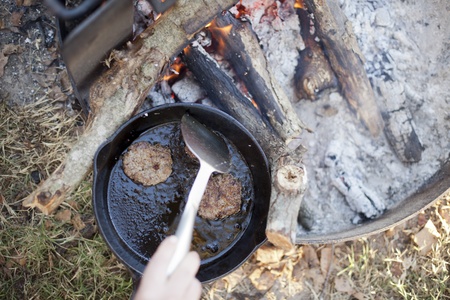 Cooking sausage for breakfast over an open campfire. の写真素材