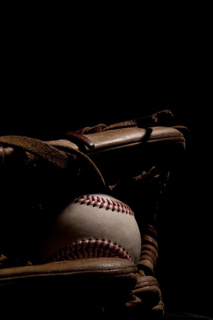 Worn baseball and glove isolated on black background  Dramatic lighting  の写真素材