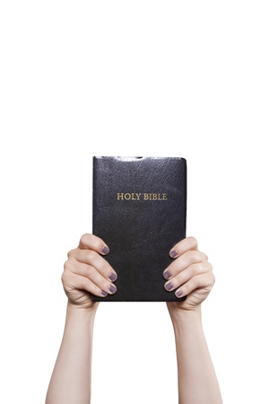 A woman holds a Bible high with two hands の写真素材