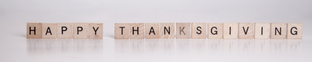 Scrabble pieces spell out Happy Thanksgiving on a white background の写真素材