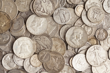 A pile of old silver coins with different prints の写真素材