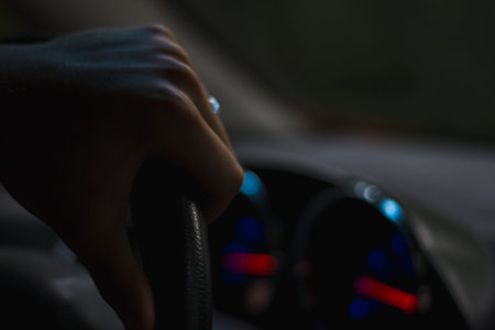 Hand on a Steering Wheel at Night