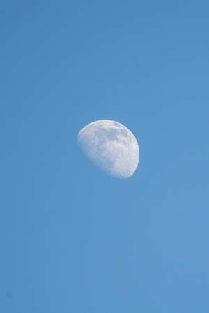partial moon at dusk on blue skyの写真素材