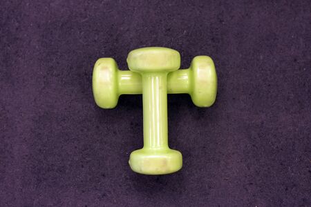 Pair of yellow dumbbells on a blue surface. Top view, close up.の写真素材