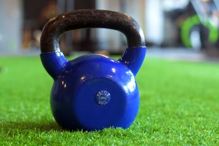 blue color kettlebells on greenery in a gymの写真素材