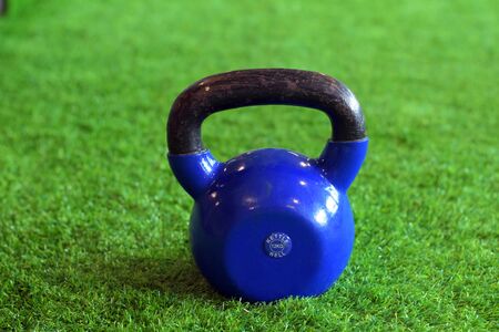 blue color kettlebells on greenery in a gymの写真素材