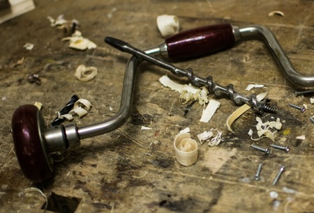 Old vintage hand drill with old drill bit and wood shavings in wood workshop for binderの写真素材