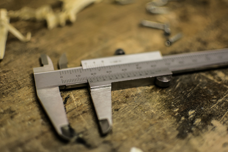 Metal caliper in a wood workshop and wood shavings with sliding calipers.の写真素材