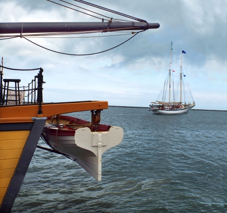 Two sailing vessels are leaving each other  One is heading to the port, and another is heading in opposite direction - to the deep sea のeditorial素材