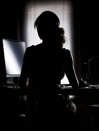A silhouette with their back turned working diligently on a computer.. AI generationの素材