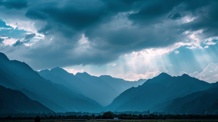 A striking contrast of immense dark mountains set against the delicate glowing clouds aboveの素材