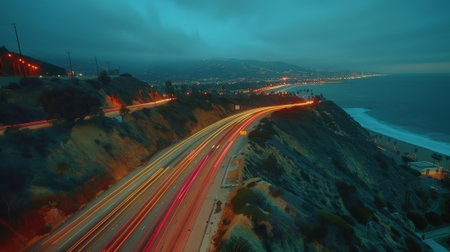 A birds eye view captures the mesmerizing light trails left by cars on a hillside roadの素材