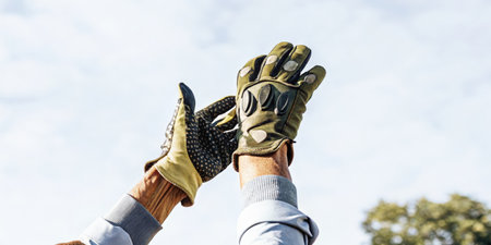 A closeup shot of an elderly persons hands gripping augmented reality gloves allowing them to manipulate digital objects floating in the air seamlessly integrated into their.の素材