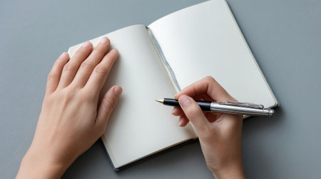 A hand holding a journal open to a blank page with a pen poised above it representing reflection selfdiscovery and the practice of journaling for mental healthの素材