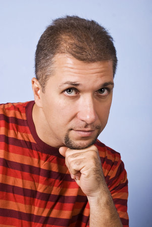 Portrait of man with beard holding his hand at chin and thinking