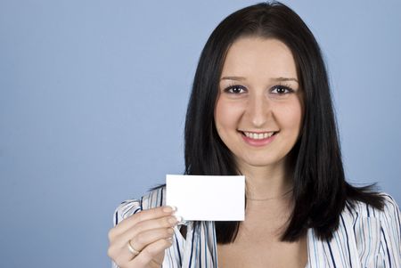 Young business woman showing a blank business card on blue backgroundの写真素材