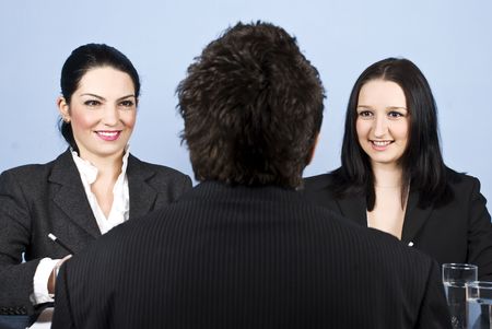 Businessman back having a job interview with two business women and they listening himの写真素材