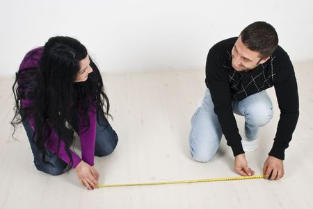 Happy couple just  moved in new home and they planning and measuring on floor  having fun and laughing togehterの写真素材