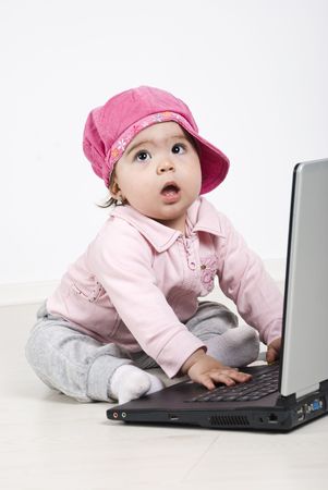 Business baby girl sitting on floor,looking away and using laptopの写真素材