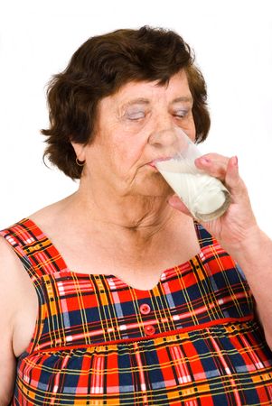 Elderly woman 80s years drinking a glass with milk isolated on white backgroundの写真素材