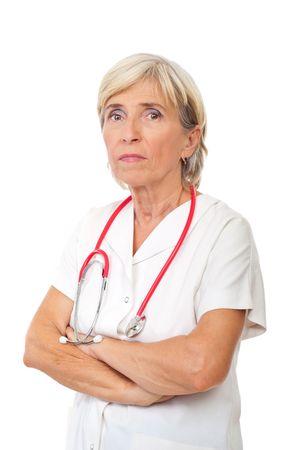 Portrait of serious senior physician woman standing with hands crossed isolated on white backgroundの写真素材