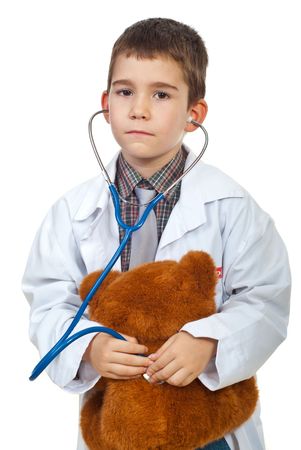 Future doctor boy examine his teddy bear with stethoscope isolated on white backgroundの写真素材