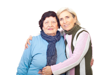 Elderly mother and senior daughter embracing and smiling isolated on white backgroundの写真素材