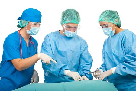 Three surgeons operating in operation room,a surgeon woman showing something to her collegueの写真素材