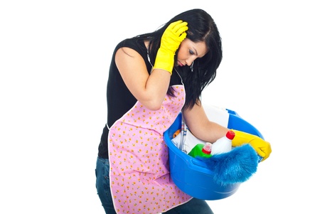 Tired sad housewife carrying a blue basin with cleaning products isolated on white backgroundの写真素材