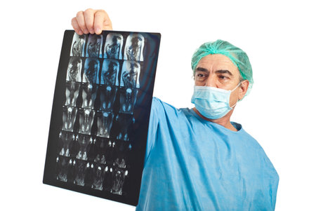 Mature surgeon man with protective mask review magnetic resonance imaging isolated on white backgroundの写真素材