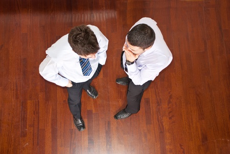 Top view of business man telling his collegue a secret and holding hands to month and the other man listening himの写真素材