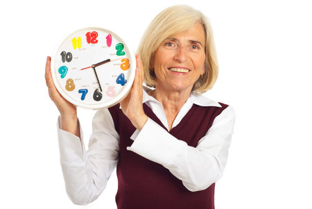 Laughing senior woman holding clock isolated on white background