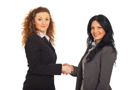 Two happy business women giving handshake isolated on white backgroundの写真素材