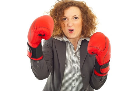 Furious business woman shouting and being in attack with boxing gloves isolated on white backgroundの写真素材