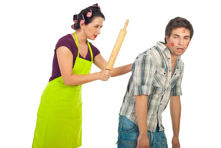 Angry wife beaut with a pin rolling her drunk unfaithful husband isolated on white backgroundの写真素材