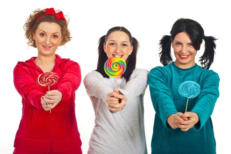 Happy three women in pyjamas giving colorful lollipos isolated on white backgroundの写真素材