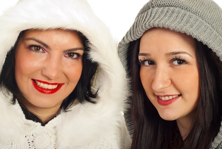 Close up of two women friends in woolen hoods isolated on white backgroundの写真素材