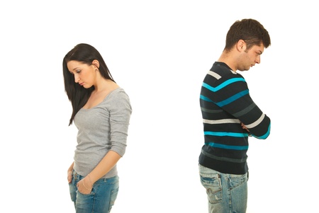 Upset couple in conflict standing back to back with arms folded isolated on white backgroundの写真素材