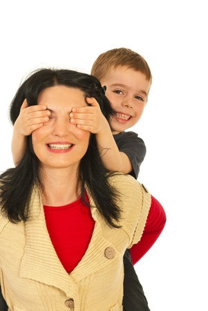 Happy mother giving piggy back ride to her son and the boy covering her eyes with palms isolated on white backgroundの写真素材