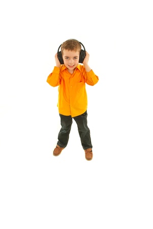Full length of kid boy listening music in headphones isolated on white backgroundの写真素材