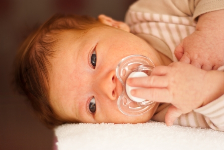 Beautiful three weeks age newborn baby boy lying don on a blanketの写真素材
