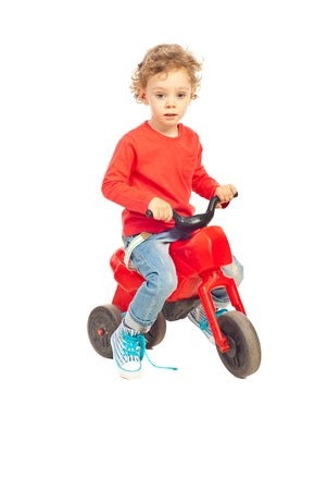 Cute toddler boy riding a bike isolated on white backgroundの写真素材