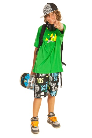 Cheerful teen boy with skateboard showing victory sign hand gesture isolated on white backgroundの写真素材