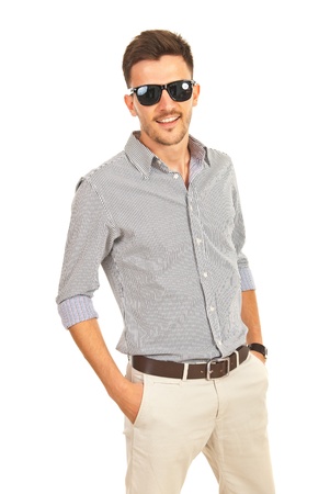Cheerful business man with sunglasses holding hands to pockets isolated on white backgroundの写真素材